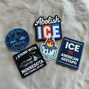 May include: A collection of embroidered patches with various designs and text. One patch reads "Abolish ICE", another "ICE AMERICAN GESTAPO". Other patches include "Minneapolis Strong" and "I Stand With Minnesota".