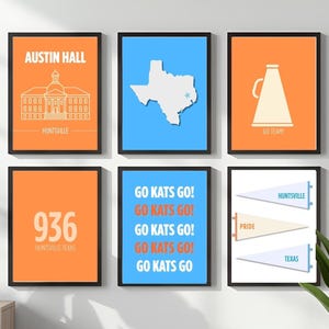 May include: Six framed art prints with black borders. The prints feature orange and blue backgrounds with white graphics and text, including a building, Texas map, megaphone, pennants, and the words "GO KATS GO!"