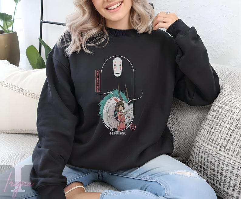 May include: Black sweatshirt featuring a graphic from the animated film, Spirited Away. The design includes the character No-Face, a dragon, and a girl in a red outfit. Japanese text is also included in the design.