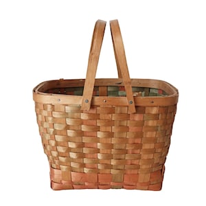 May include: A woven wicker basket with two handles. The basket is made of natural wood and has a light brown colour with hints of pink and green.