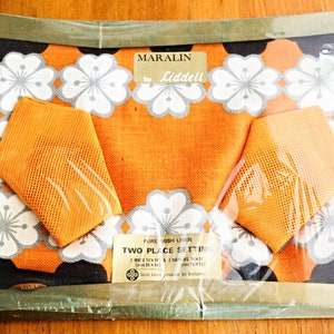 Puede incluir: Un juego de dos manteles individuales y servilletas de lino de color naranja y blanco con motivos florales. La caja está etiquetada con "Maralin by Liddell" y "Pure Irish Linen Two Place Setting".