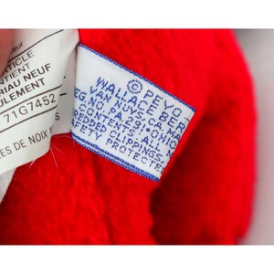 May include: A blue and white label with the text "PEYO-BEBE FRANCE WALLACE, CA. OHIO EG. NO. PA. 231 ALL CONTENTS REDDED CLIPPINGS SAFETY PROTECTED" on a red fabric background.