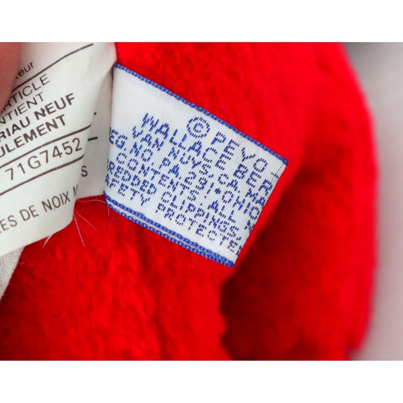 May include: A blue and white label with the text "PEYO-BEBE FRANCE WALLACE, CA. OHIO EG. NO. PA. 231 ALL CONTENTS REDDED CLIPPINGS SAFETY PROTECTED" on a red fabric background.