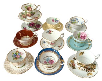 Può includere: Una collezione di nove tazze da tè e piattini in ceramica con vari motivi floreali, fruttati e bordi dorati. Il set include pezzi con bordi smerlati, rose dipinte, pere e intricati motivi dorati su sfondi bianchi, blu e rossi.