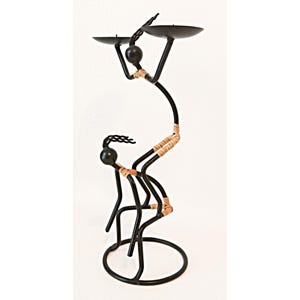 May include: Black metal candle holder shaped like two stylized figures, one holding the other up. The figures are wrapped with tan twine. The top figure holds a black candle plate.