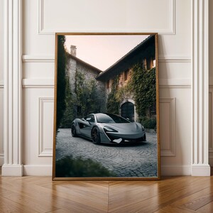 Könnte beinhalten: Gerahmter Druck mit einem grauen Sportwagen, der auf einer gepflasterten Auffahrt geparkt ist. Das Auto steht vor einem mit Grün bedeckten Steingebäude. Der Druck hat einen Holzrahmen.