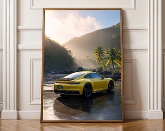 May include: Framed print featuring a yellow sports car parked near a river with a tropical backdrop. The car is the focal point, with a mountain range, palm trees, and sunlight adding to the scenic view. The print is displayed on a wooden floor.