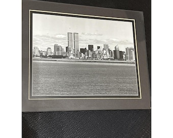 Foto em preto e branco das Torres Gêmeas de Nova York na orla marítima, 20 x 25 cm, emoldurada e com passe-partout duplo.