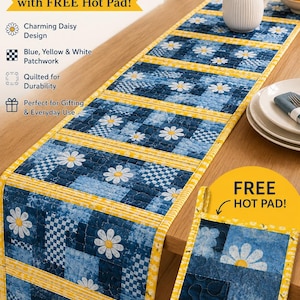 May include: A quilted table runner and matching hot pad featuring a blue, yellow, and white patchwork design with daisy motifs. The runner measures 47 inches by 15 inches. The set includes text reading Bloom & Bright TABLE RUNNER.