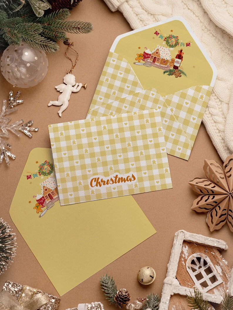 May include: Christmas greeting cards with yellow gingham pattern and matching envelopes. The cards feature the word "Christmas" in a script font. The envelopes have a festive illustration of a gingerbread house and other holiday elements.