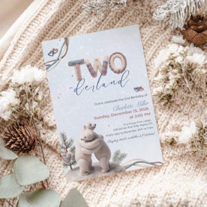 May include: A rectangular birthday invitation card featuring two polar bears hugging, with the text "TWO-derland" at the top. The card includes event details for Charlotte Miller on Sunday, December 13, 2026, at 2:00 PM at The Frosty Pine Lodge.