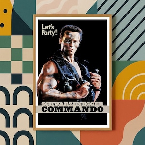 May include: Framed poster of Arnold Schwarzenegger from the film Commando. The image shows Schwarzenegger in a tactical vest, holding weapons. Text includes "Let's Party!" and "SCHWARZENEGGER COMMANDO". The poster is in a wooden frame.