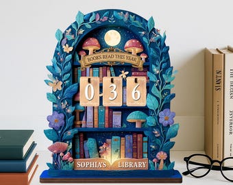 May include: A whimsical wooden bookshelf-shaped perpetual calendar in shades of blue, featuring a moon, mushrooms, and floral accents. The calendar displays "036" and reads "BOOKS READ THIS YEAR" and "SOPHIA'S LIBRARY".