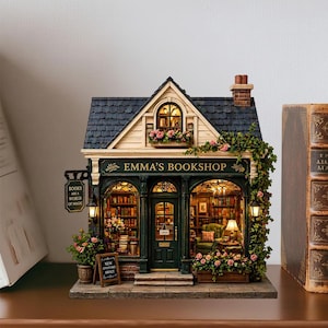 May include: A miniature replica of "Emma's Bookshop" with a dark green facade, a black roof, and a sign that reads "Books Are a World of Magic." The shop is adorned with flowers and features a detailed interior with bookshelves and a cozy reading area.
