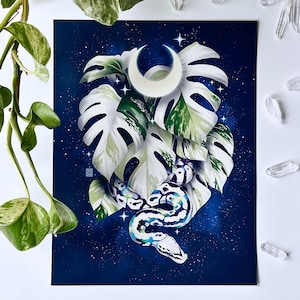 May include: Art print featuring a stylized snake intertwined with large white and green leaves, a crescent moon, and stars against a dark blue, starry background. The artwork has a celestial and botanical theme.