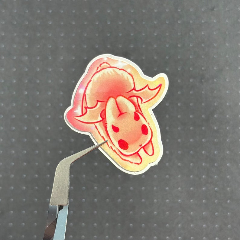 May include: A sticker featuring a cartoon bunny with red and pink accents. The bunny has large ears and is depicted in a playful pose.