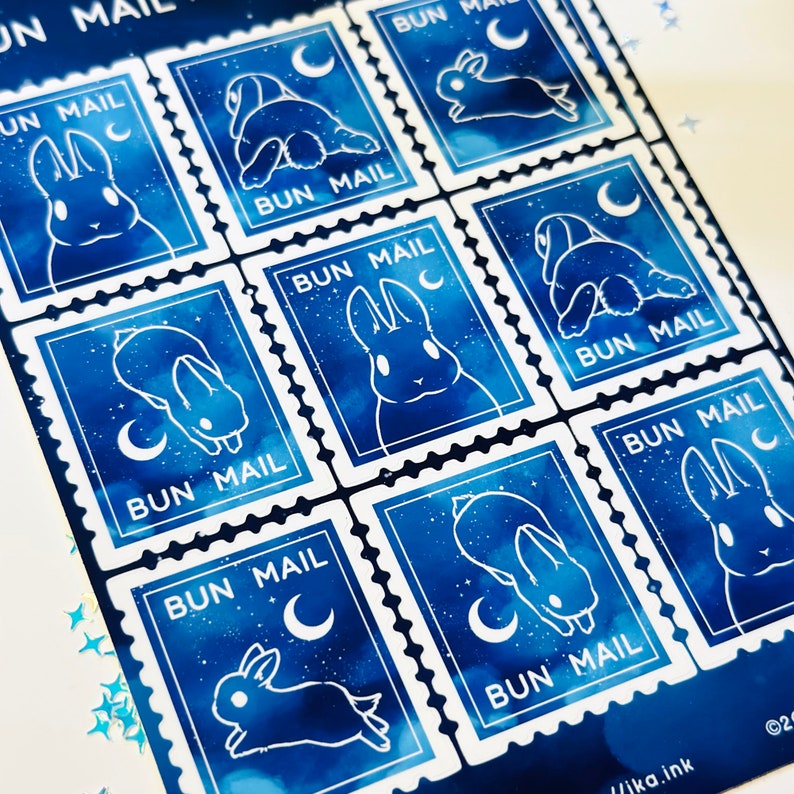 May include: Nine blue and white bunny stamps with the text "BUN MAIL" and a crescent moon. The stamps have a watercolour-like background with white stars.