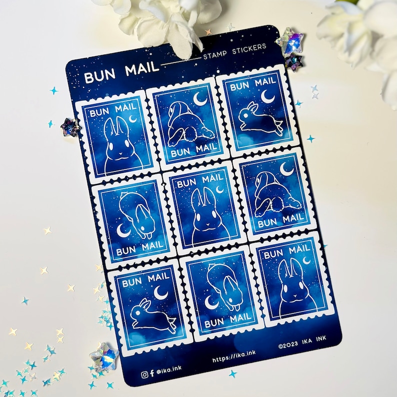May include: A sheet of eight blue and white bunny stamp stickers with the text "BUN MAIL" on each stamp. The stamps feature a white bunny with a crescent moon and stars on a blue background.