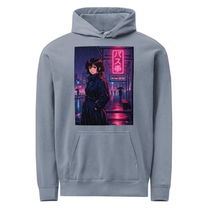 Könnte beinhalten: Hellblauer Kapuzenpullover mit einer Illustration im Anime-Stil. Das Kunstwerk zeigt eine Person in einem schwarzen Mantel im Regen in der Nähe einer Bushaltestelle mit japanischem Text und einem Neonschild. Der Hoodie hat eine Vordertasche und eine Kapuze.