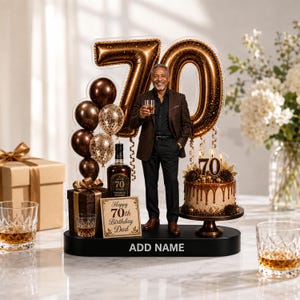 Può includere: Un topper per torta per il 70° compleanno con la sagoma di una persona in abito che tiene un bicchiere, grandi palloncini color bronzo metallizzato a forma di 70, una bottiglia di whisky, un regalo e una torta su una base nera ADD NAME.