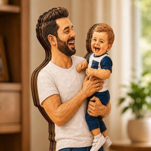 May include: A layered wooden cutout sculpture depicting a smiling adult with a beard wearing a white t-shirt, holding a laughing toddler who is dressed in a white and navy blue short-sleeved outfit with white shoes. The piece has visible wood grain edges.