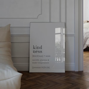 Pode incluir: Impressão emoldurada com a palavra "kindness" e sua definição. O texto inclui "merciful, gracious & tender temperament" e uma referência bíblica. A impressão é exibida contra uma parede branca.