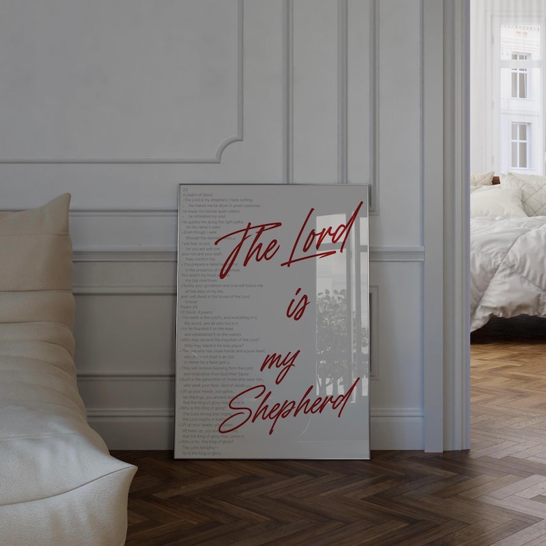 May include: A framed print with the words "The Lord is my Shepherd" in red script. The print has a white background with the full text of Psalm 23 in a light gray font. The frame is a light gray color.