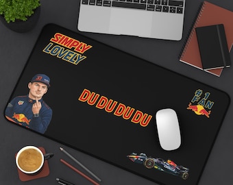 May include: Black rectangular desk mat featuring a Formula 1 theme. The mat has the text "SIMPLY LOVELY" and "DU DU DU DU". It also features a cartoon image of a driver and a race car. A computer mouse is on the mat.
