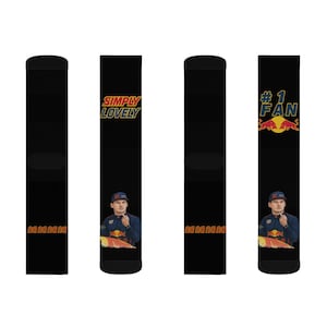 May include: Black socks featuring a portrait of a man in a racing uniform. One sock has the text "SIMPLY LOVELY", and another says "#1 FAN" with a logo. The socks have the text "na na na na" on the sides.