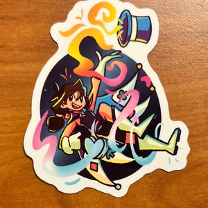 May include: A colorful sticker featuring a cartoon illustration of a person performing a magic trick. The person is wearing a black outfit and is surrounded by colorful swirls and a top hat. The background is dark blue.