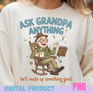 May include: Cream-colored sweatshirt with the text "ASK GRANDPA ANYTHING" and a cartoon illustration of an elderly man in a rocking chair. The man is holding a mug that says "WORLD'S BEST" and a book titled "TOTALLY TRUE TALES (Probably)".
