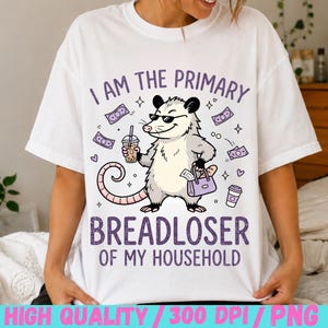 May include: A white t-shirt featuring a graphic of an opossum wearing sunglasses, holding a boba drink and a purple handbag. The text reads I AM THE PRIMARY BREADLOSER OF MY HOUSEHOLD, surrounded by purple dollar bills, hearts, and a coffee cup.