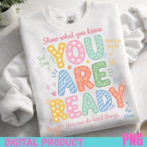 Könnte beinhalten: Weißes Sweatshirt mit einem farbenfrohen Grafikdesign mit der Aufschrift "YOU ARE READY". Das Design enthält Sterne, Herzen und die Sätze "Show what you know", "Test Day" und "You can do hard things."