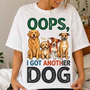 Puede incluir: Una camiseta blanca con un gráfico de cuatro perros de diferentes razas sentados juntos. Sobre los perros, el texto dice OOPS, y debajo, el texto dice I GOT ANOTHER DOG en letras grandes, negritas y de color oscuro.