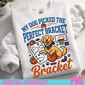 May include: White sweatshirt with a graphic featuring a golden retriever with a blue bandana, basketballs, and a bracket. Text reads "MY DOG PICKED THE PERFECT BRACKET" in blue and orange. Paw prints and a basketball hoop are also included.