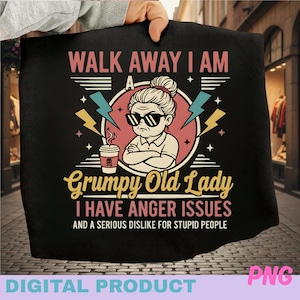Puede incluir: Camiseta negra con texto "WALK AWAY I AM A Grumpy Old Lady I HAVE ANGER ISSUES AND A SERIOUS DISLIKE FOR STUPID PEOPLE." El diseño presenta una caricatura de una mujer con gafas de sol y una taza de café.