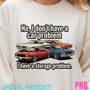 May include: White sweatshirt featuring a graphic of four classic cars in red, blue, orange, and white. The text reads, "No, I don't have a car problem. I have a storage problem." Below the text is "DIGITAL PRODUCT" and "PNG".