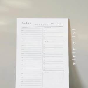 May include: A white notepad with a minimalist design. The word "today" is at the top, with sections for schedule, priorities, to-do list, and notes. The right side of the notepad has the word "minimalist" written vertically.