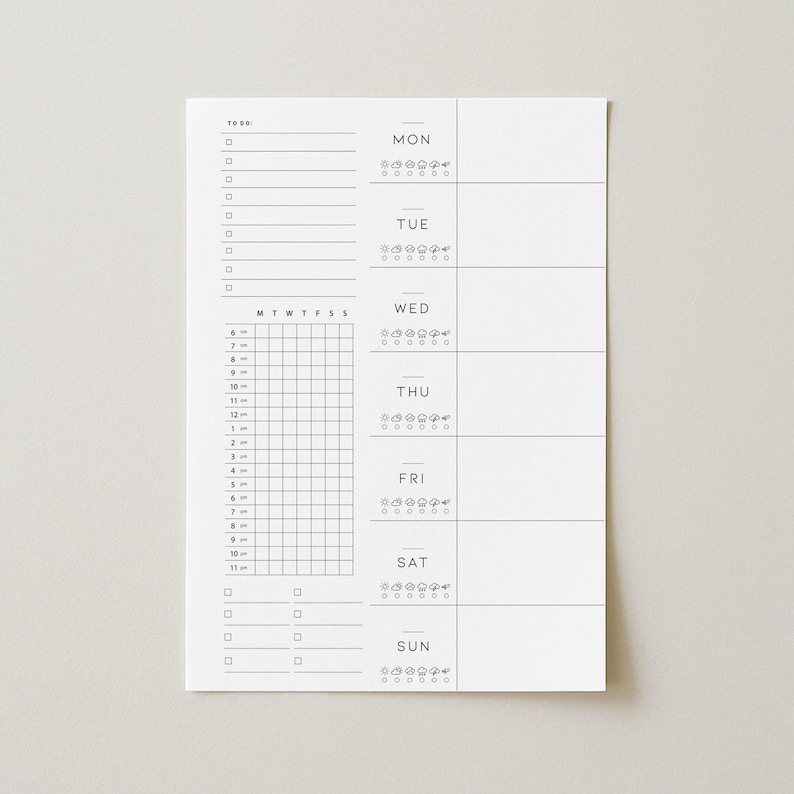 May include: A white weekly planner with a minimalist design. The planner includes sections for each day of the week, a to-do list, and a time-based schedule. The days of the week are labeled in a simple font, and there are small icons for each day.
