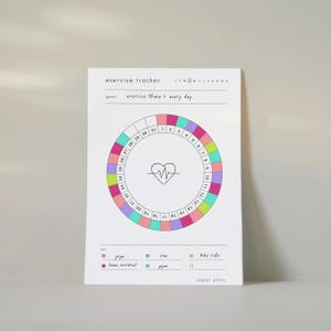 Op de afbeelding: Een witte papieren oefentracker met een cirkelvormige kalender met de cijfers 1 tot en met 31. In het midden staat een hart met een EKG-lijn. Bovenaan staat exercise tracker en goal: exercise 15min + every day. Een kleurgecodeerde legenda vermeldt yoga, home workout, run, gym en bike ride.