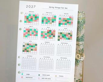 May include: A 2027 paper planner insert featuring a yearly calendar with colour-coded activity tracking for January through June. The grid includes a key for yoga, meditation, nature walks, and library visits, with the text doing things for me.