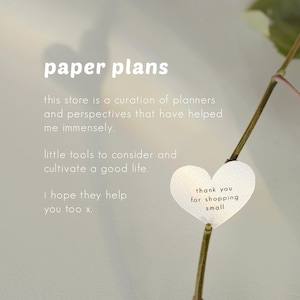 May include: The image features the text "paper plans" at the top, with additional text below describing the store's focus on planners and perspectives. A heart-shaped tag reads "thank you for shopping small."
