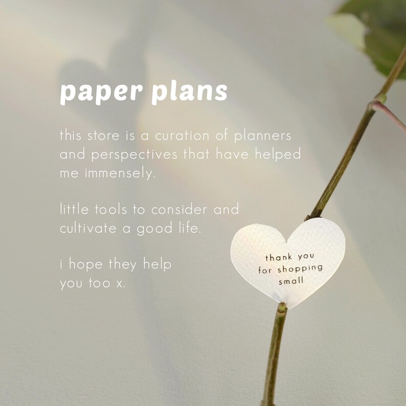 May include: The image features the text "paper plans" at the top, with additional text below describing the store's focus on planners and perspectives. A heart-shaped tag reads "thank you for shopping small."