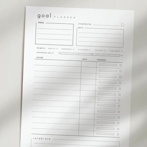 May include: A minimalist white goal planner sheet with black text. The top section includes fields for 'Goal' and 'complete by'. Below are sections for 'Action', 'Date', and 'Progress'. The planner also has a progress bar and a section to 'celebrate'.