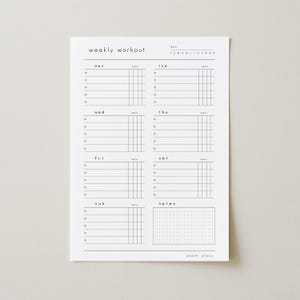 Op de afbeelding: Een witte papieren wekelijkse workout planner met zwarte tekst en lijnen. De planner bevat secties voor elke dag van de week, met ruimte voor sets en notities. De tekst "weekly workout" en "paper plans" zijn zichtbaar.