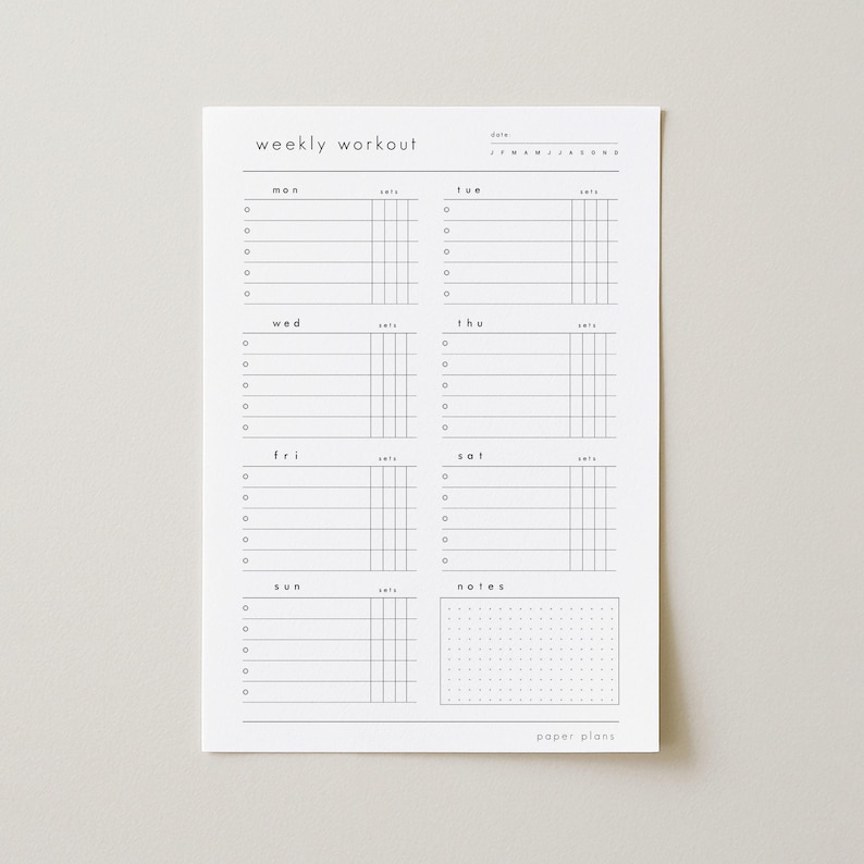 May include: A white paper weekly workout planner with black text and lines. The planner includes sections for each day of the week, with space for sets and notes. The text "weekly workout" and "paper plans" are visible.