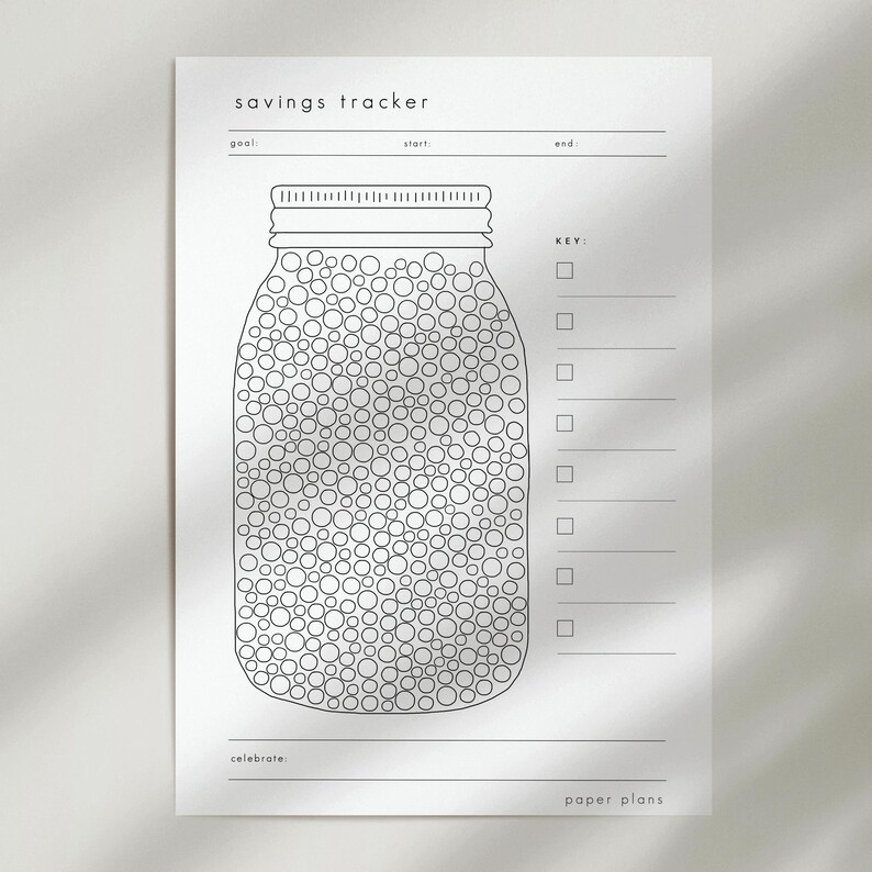 May include: A white savings tracker sheet with a jar graphic filled with circles. The text "savings tracker" is at the top, with lines for goal, start, and end. A key and celebrate section are also included.