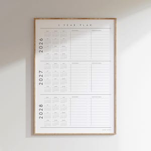 May include: A framed 3-Year Plan calendar with a minimalist design. The calendar includes the years 2026, 2027, and 2028, with space for personal and professional notes. The text "3 YEAR PLAN" is at the top.