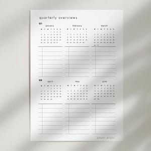 May include: A white paper with a quarterly overview calendar. The calendar includes the months of January, February, March, April, May, and June. The text "quarterly overviews" and "paper plans" are printed on the paper.