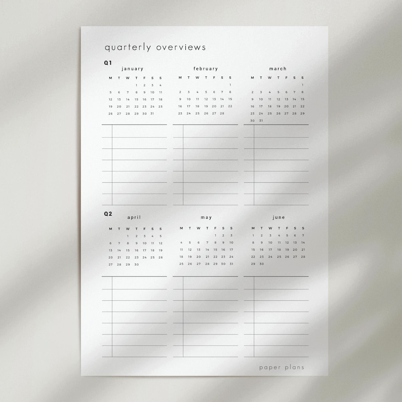 May include: A white paper with a quarterly overview calendar. The calendar includes the months of January, February, March, April, May, and June. The text "quarterly overviews" and "paper plans" are printed on the paper.
